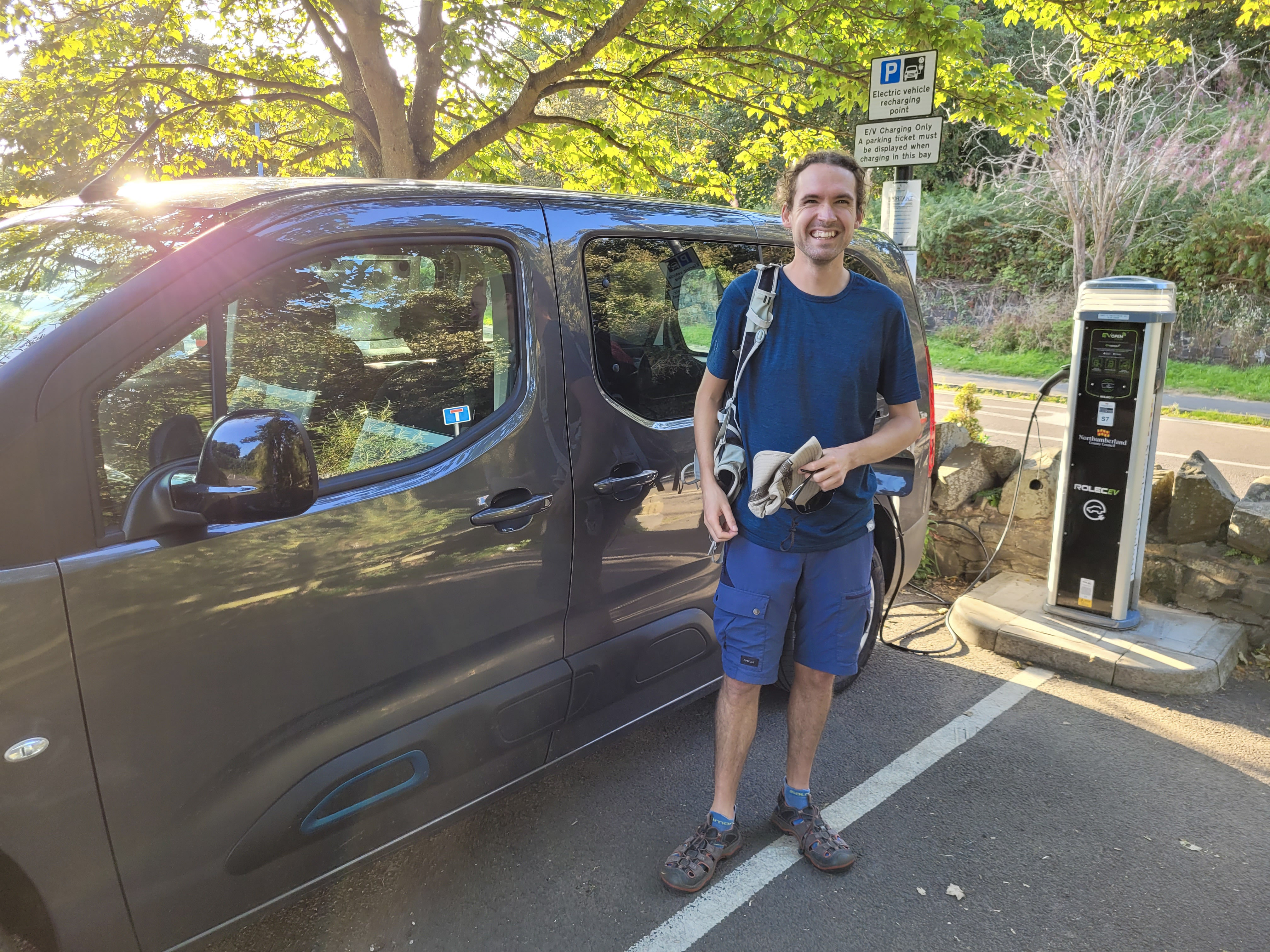 Photo of the author in front of a car plugged into an electric vehicle charger