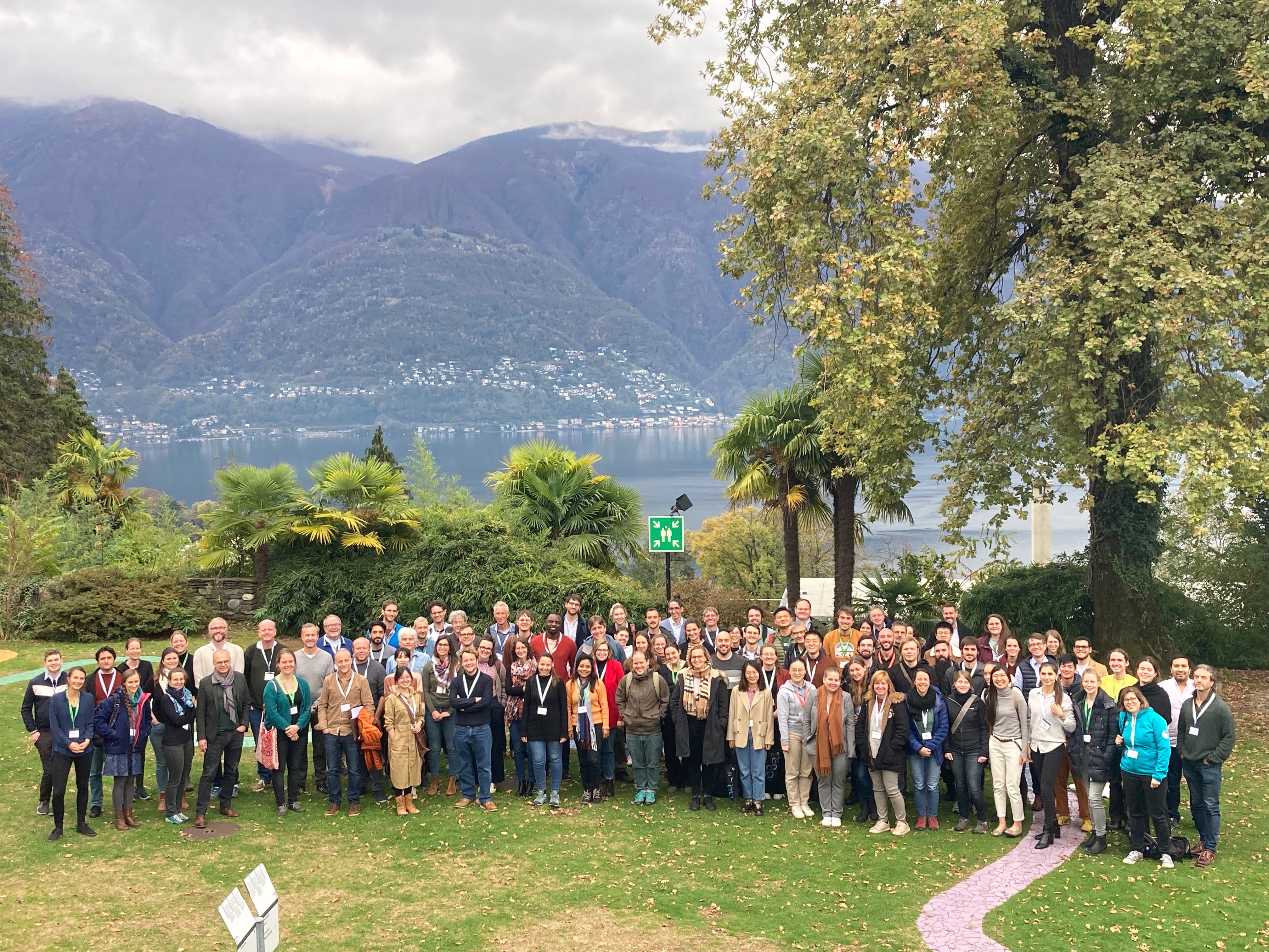 Photo of a large group of people posing for a group photo infront of a lake